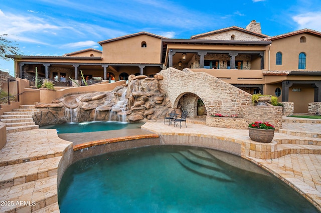 view of swimming pool with pool water feature