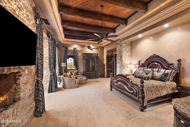 bedroom with beam ceiling, a stone fireplace, wood ceiling, and light carpet