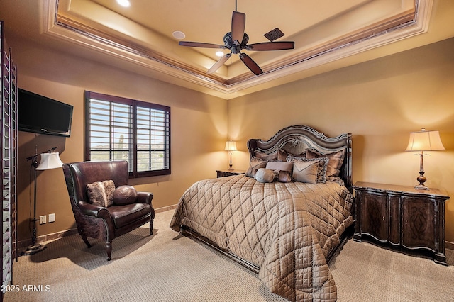 bedroom featuring ceiling fan, a raised ceiling, ornamental molding, and carpet floors