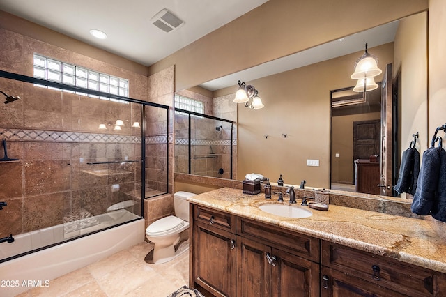 full bathroom with tile patterned flooring, vanity, toilet, and bath / shower combo with glass door