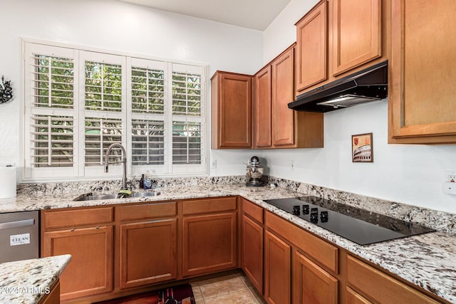 kitchen featuring black electric stovetop, light stone counters, a healthy amount of sunlight, and sink