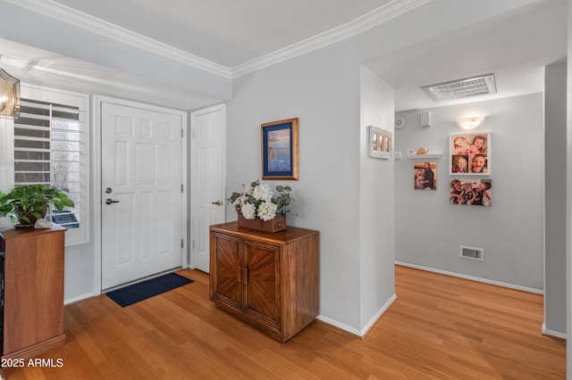 foyer with crown molding and light hardwood / wood-style flooring