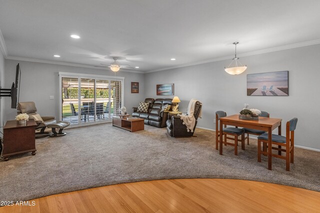 living room featuring hardwood / wood-style flooring, crown molding, and ceiling fan