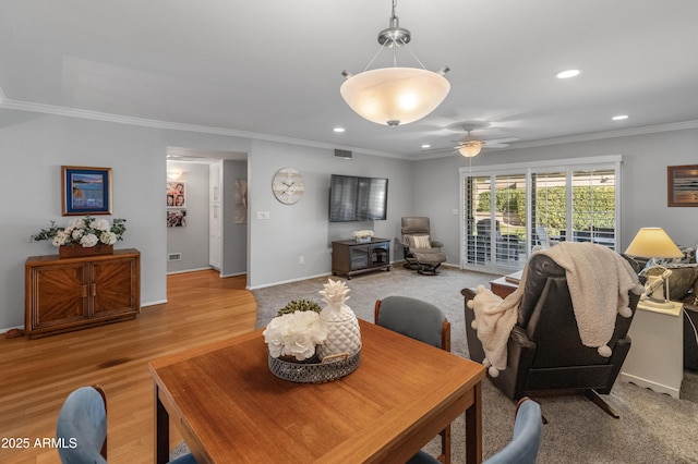 living room with crown molding, ceiling fan, and light hardwood / wood-style flooring