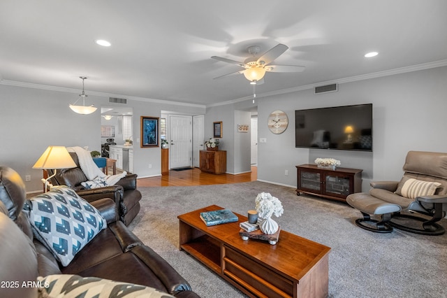 living room with crown molding, light colored carpet, and ceiling fan