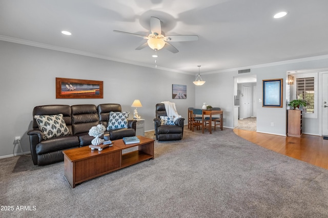 living room featuring ornamental molding, ceiling fan, and carpet flooring