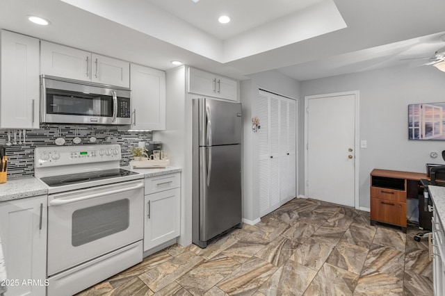 kitchen featuring white cabinetry, appliances with stainless steel finishes, ceiling fan, and decorative backsplash