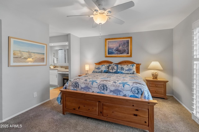 bedroom featuring ceiling fan, light colored carpet, and ensuite bathroom