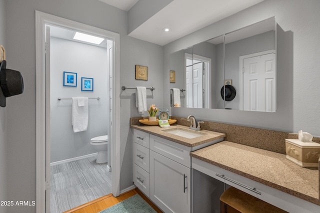 bathroom featuring vanity, toilet, and wood-type flooring