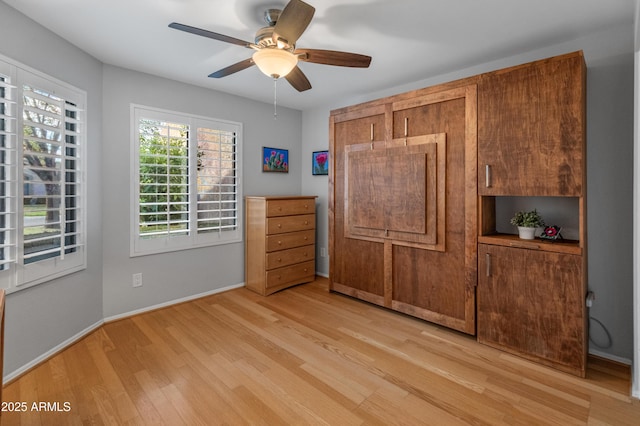 unfurnished bedroom with ceiling fan and light hardwood / wood-style flooring