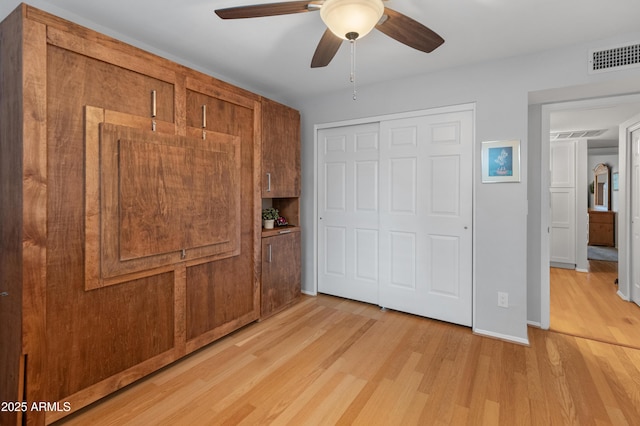 unfurnished bedroom with a closet, ceiling fan, and light hardwood / wood-style flooring