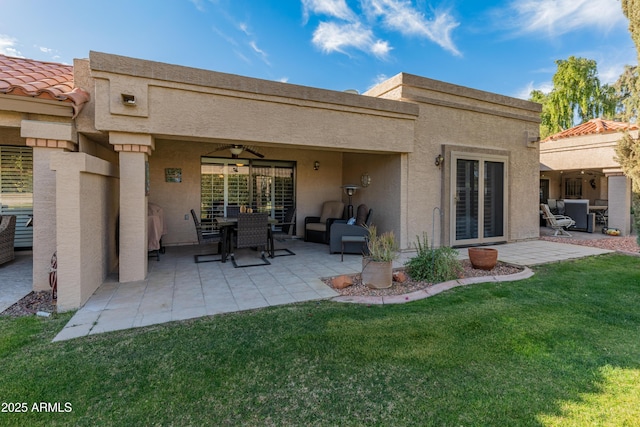 rear view of house featuring a yard, a patio area, and ceiling fan