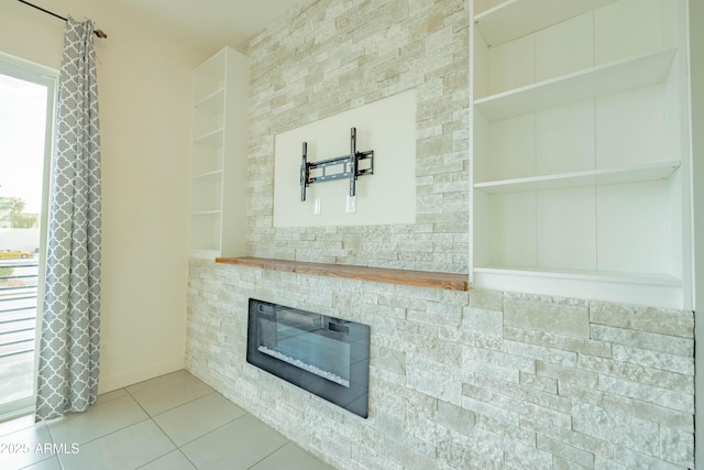 interior details with a stone fireplace and built in shelves