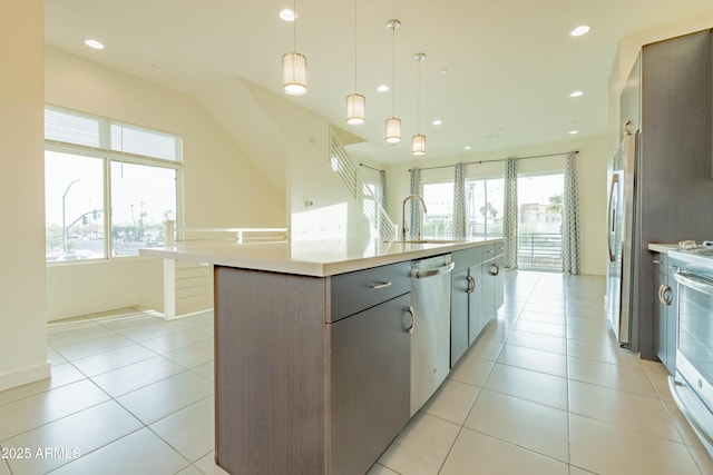 kitchen featuring pendant lighting, plenty of natural light, a large island with sink, and stainless steel appliances