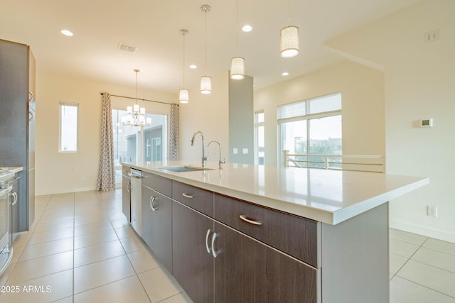 kitchen featuring sink, pendant lighting, a center island with sink, and a wealth of natural light