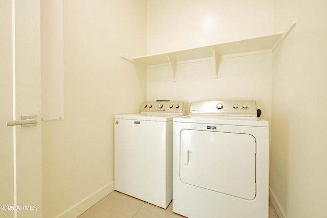 laundry area featuring washing machine and dryer and light tile patterned floors