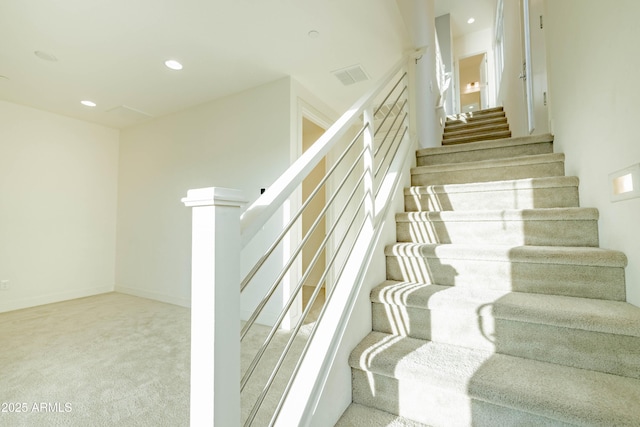 staircase featuring carpet flooring