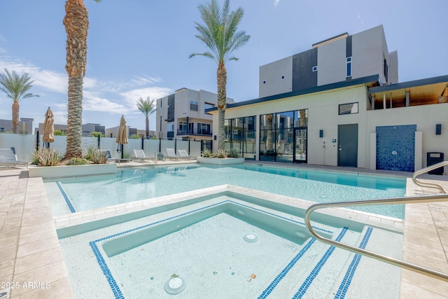 view of pool with a hot tub and a patio