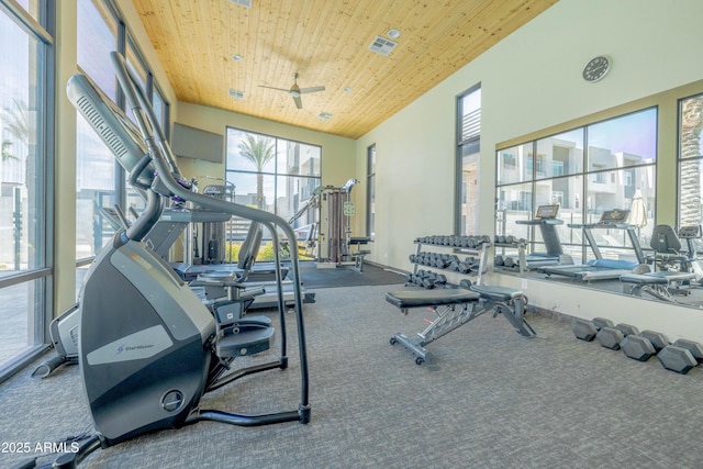 workout area featuring wooden ceiling, a towering ceiling, and ceiling fan