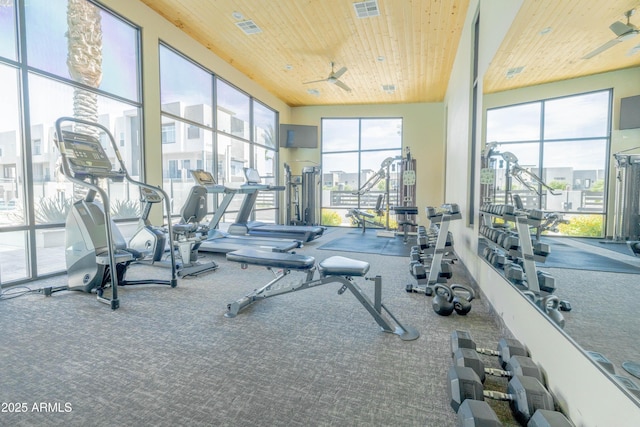 workout area featuring ceiling fan, a towering ceiling, and wooden ceiling