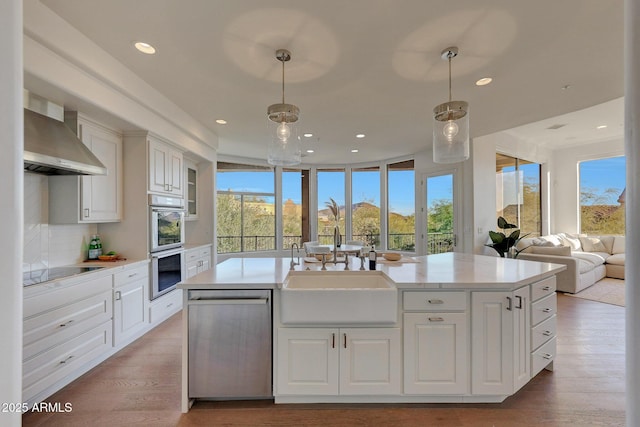 kitchen featuring stainless steel appliances, pendant lighting, and white cabinetry