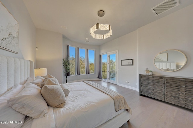 bedroom with access to outside and wood-type flooring