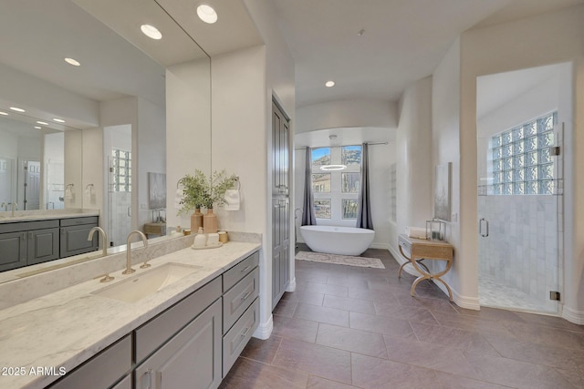 bathroom with tile patterned flooring, independent shower and bath, and vanity