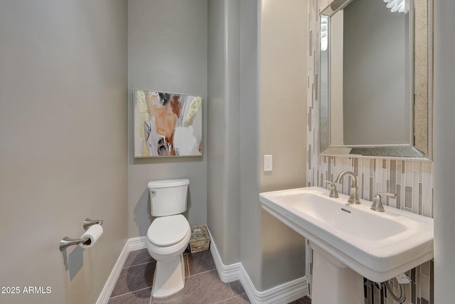 bathroom with toilet, sink, tile patterned floors, and decorative backsplash