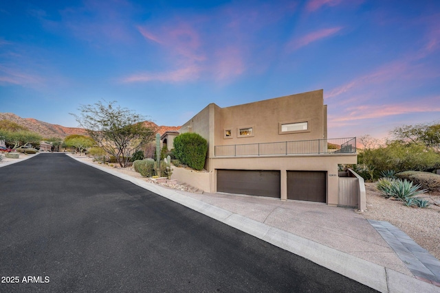 pueblo revival-style home with a balcony, a garage, and a mountain view