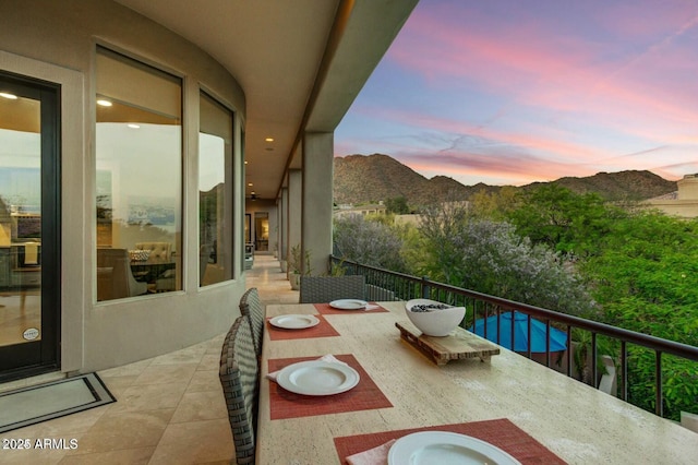 balcony at dusk featuring a mountain view