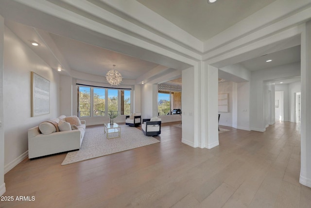 living room featuring light wood-type flooring and a chandelier