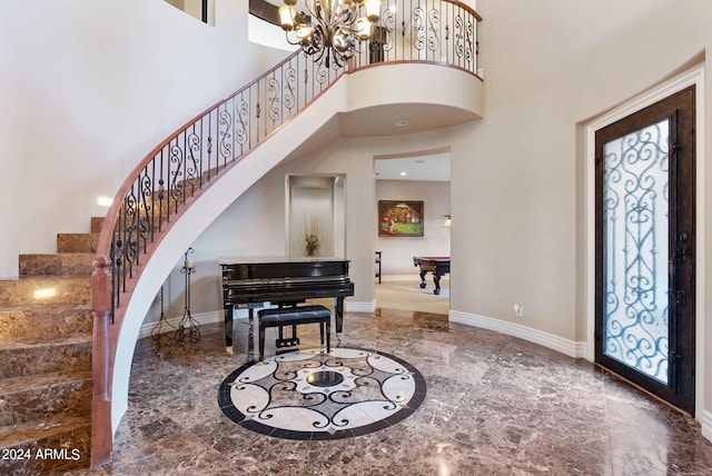 entrance foyer featuring an inviting chandelier, a high ceiling, and tile patterned flooring