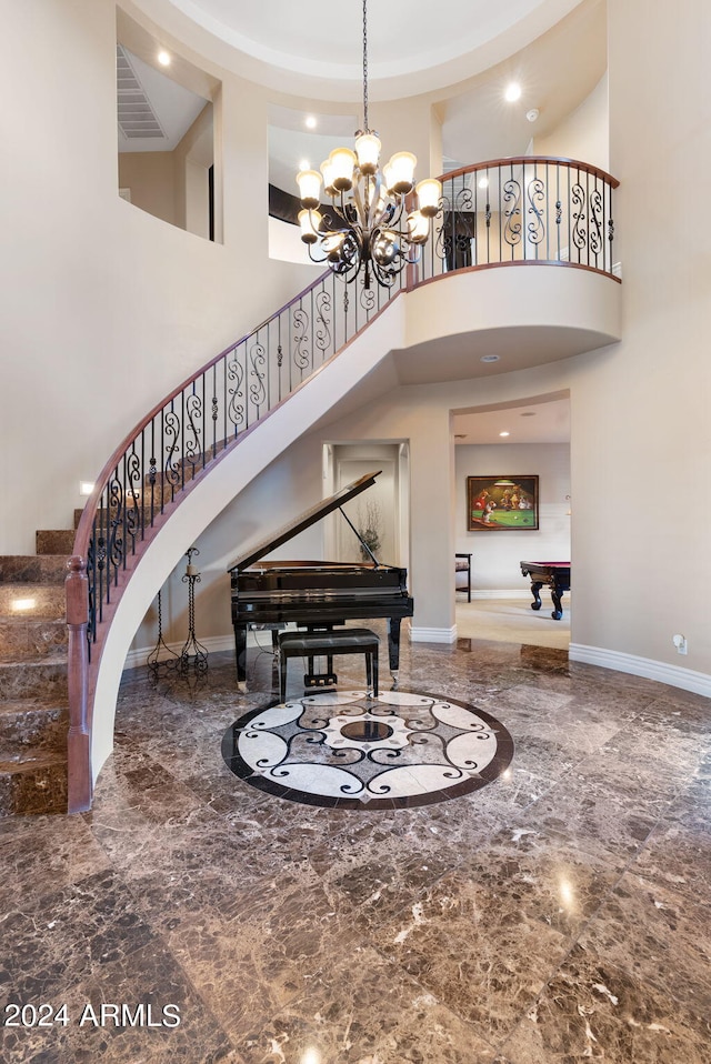 interior space featuring tile patterned flooring, a high ceiling, and an inviting chandelier