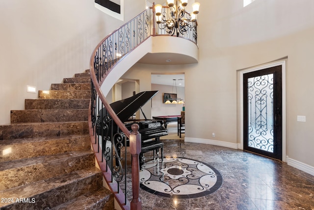 tiled entryway with a towering ceiling and an inviting chandelier