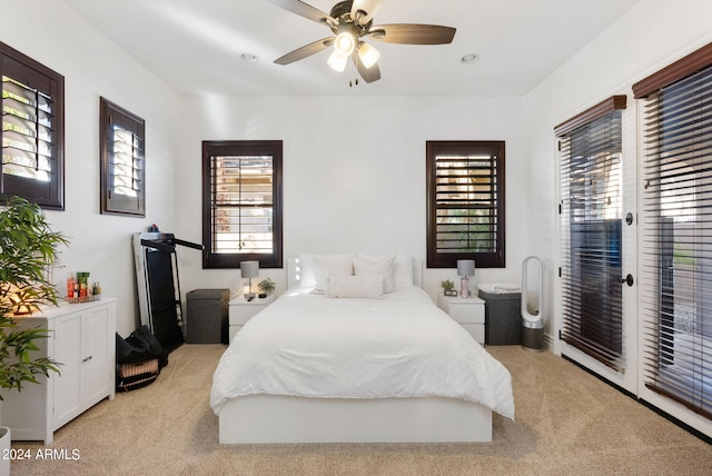 carpeted bedroom featuring access to exterior, ceiling fan, and multiple windows