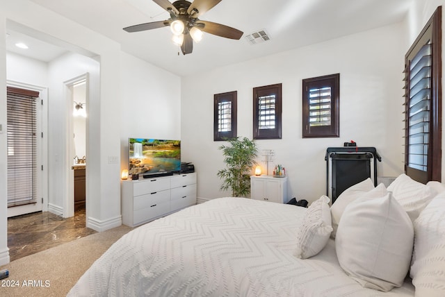 bedroom with tile patterned flooring, ceiling fan, and connected bathroom