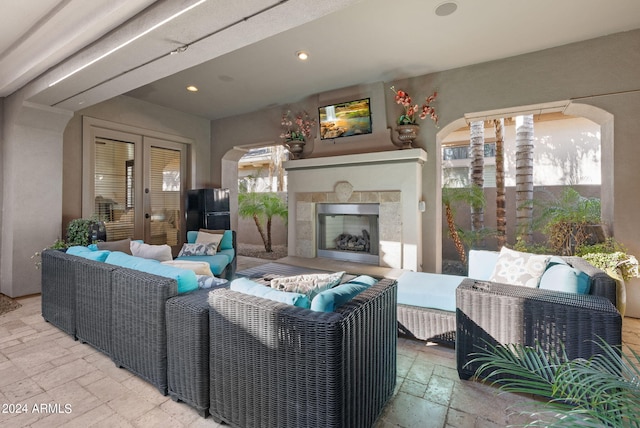 tiled living room with a fireplace and french doors