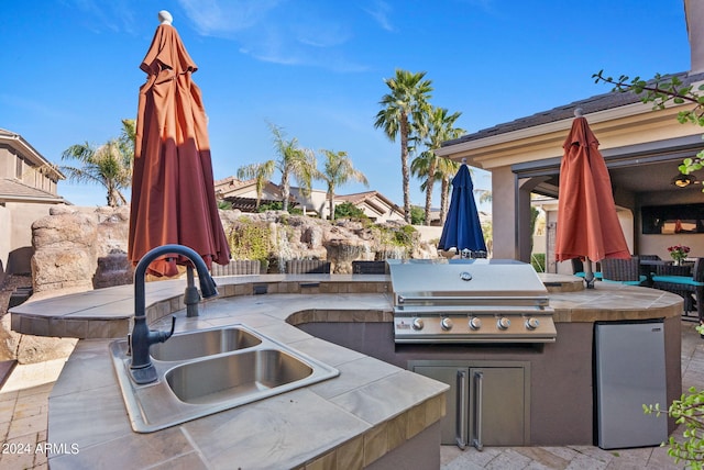 view of patio with an outdoor kitchen, sink, and a grill