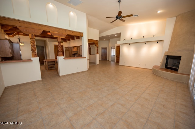 unfurnished living room featuring a fireplace, light tile flooring, and ceiling fan