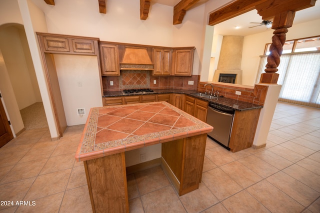 kitchen featuring kitchen peninsula, ceiling fan, appliances with stainless steel finishes, sink, and premium range hood