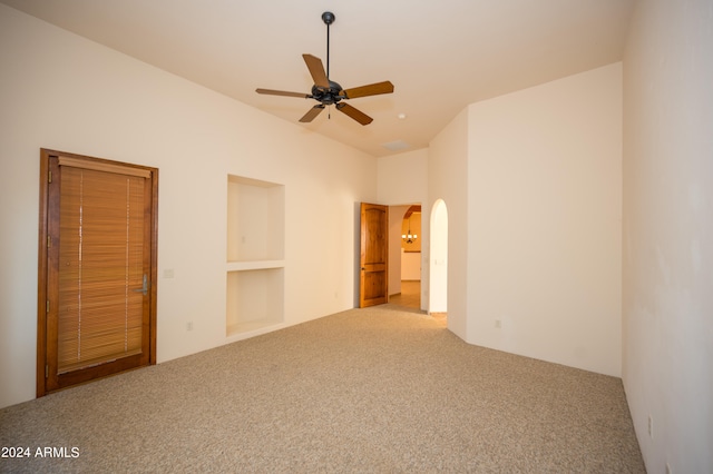 unfurnished bedroom with a towering ceiling, a closet, carpet, and ceiling fan