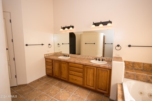 bathroom with dual vanity, tile floors, and a tub