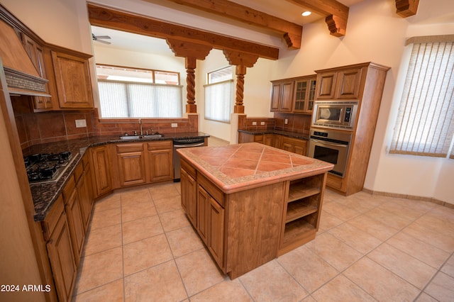 kitchen featuring backsplash, appliances with stainless steel finishes, sink, and light tile floors