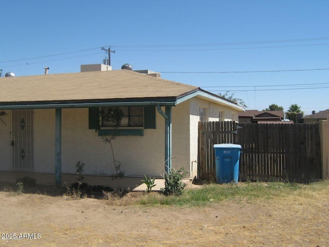 view of home's exterior with fence and stucco siding