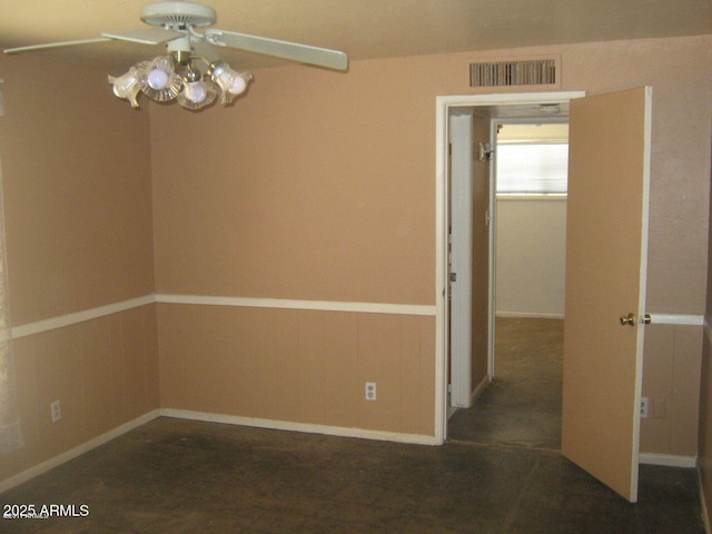 unfurnished room with visible vents and wainscoting