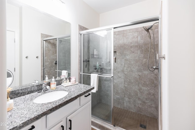 bathroom with a shower with shower door and vanity