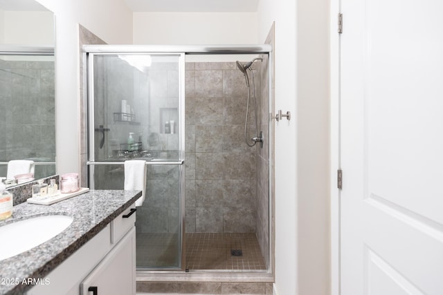 bathroom with vanity and a shower with door