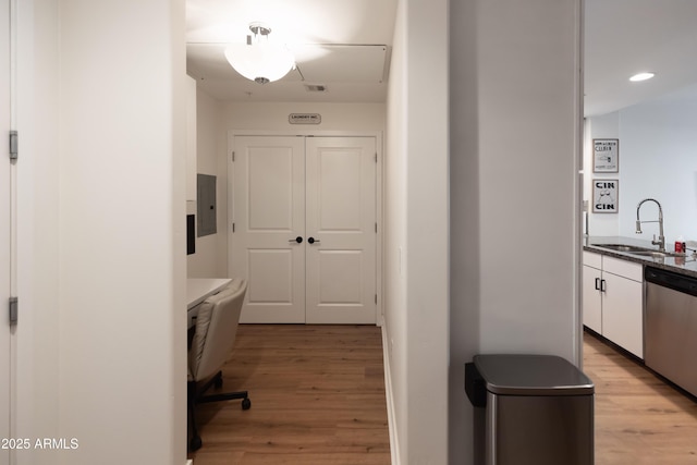 interior space featuring light wood-type flooring, electric panel, and sink