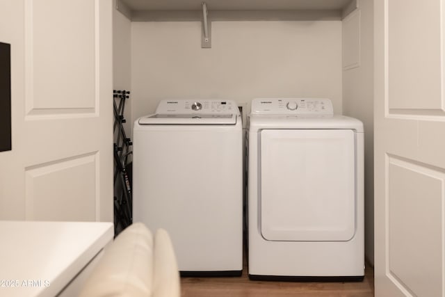 laundry room with separate washer and dryer and light hardwood / wood-style flooring