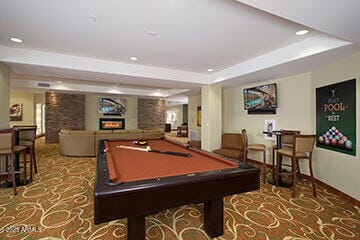 playroom featuring pool table, a raised ceiling, and a fireplace